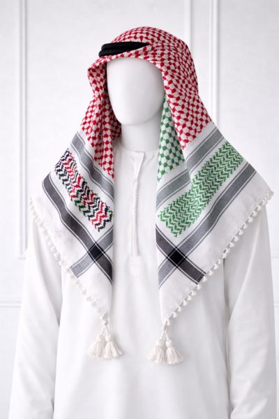 Traditional white keffiyeh shemagh scarf featuring red, green and black woven patterns with decorative tassel edges worn with a white thobe.