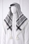 Classic white keffiyeh shemagh scarf featuring black geometric patterns and tassel edges worn over a white thobe for a traditional Arabic look.