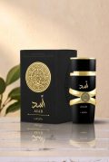 Lattafa Asad 100ml perfume for men in a luxury black and gold bottle with a circular lion crest shield next to its original packaging box.